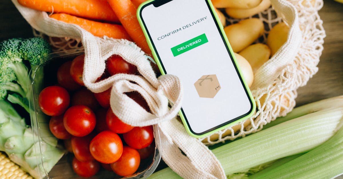 A smartphone displays delivery confirmation amidst fresh vegetables, signifying convenience and freshness.
