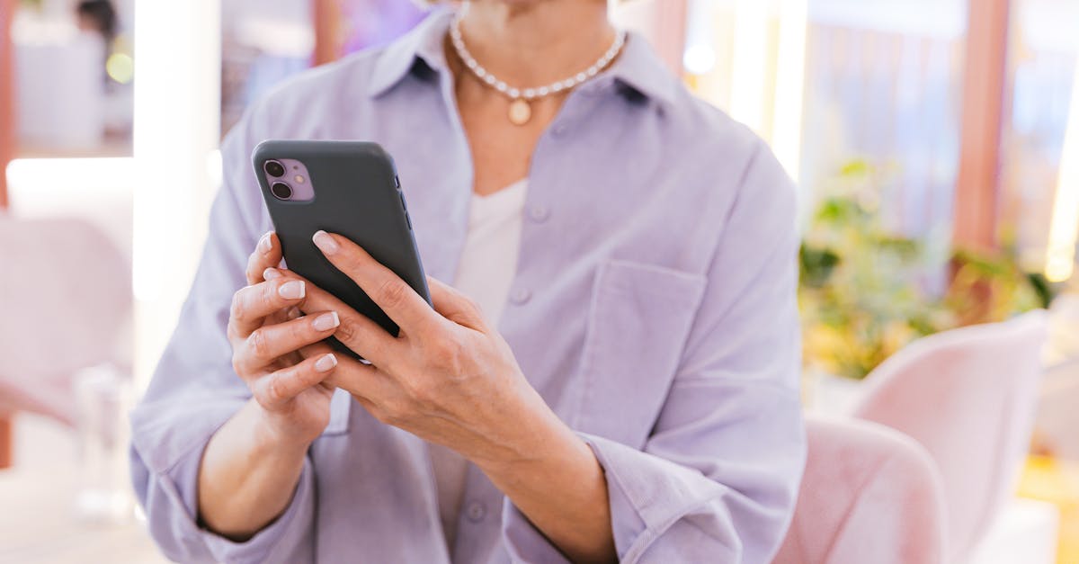 Adult woman using smartphone indoors. Bright and modern setting with plants.