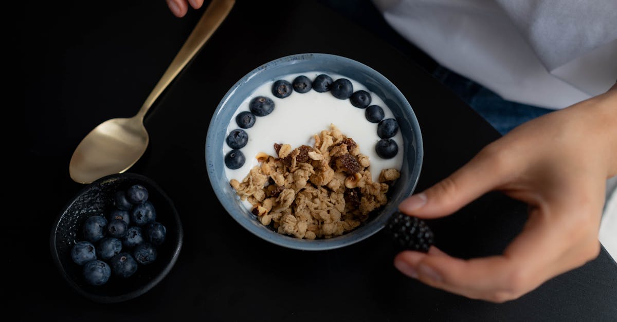 A delicious breakfast bowl featuring granola, yogurt, blueberries, and blackberries, perfect for a healthy start.