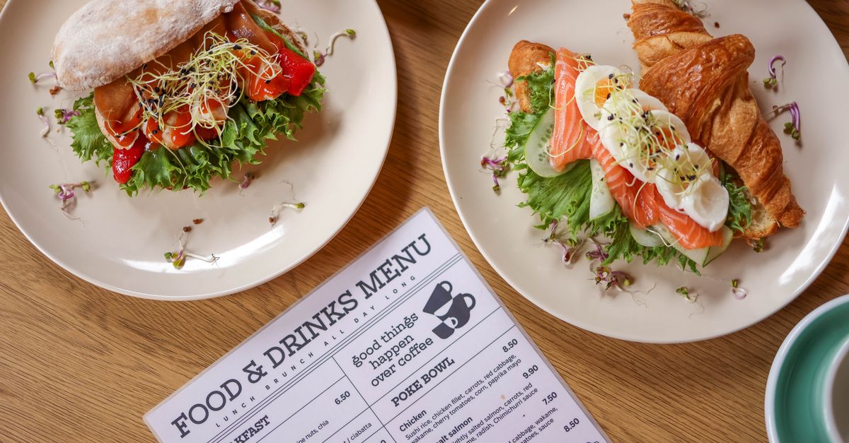 Top view of delicious salmon croissant and sandwich with fresh ingredients on wooden table.